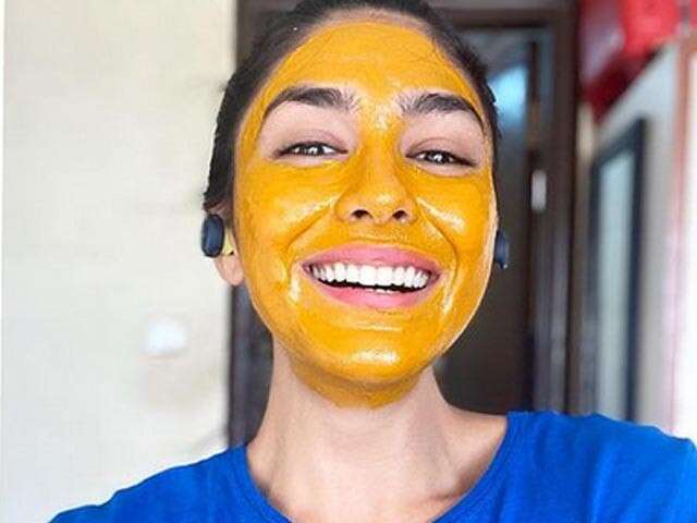 A beautiful girl smiling applying basen on her face